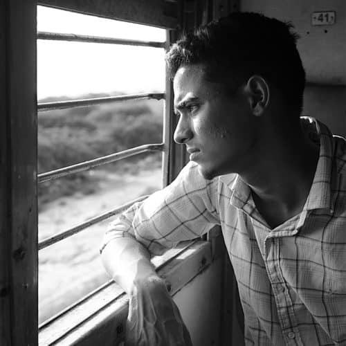 Jeune indien regardant par la fenêtre d'un train en Inde