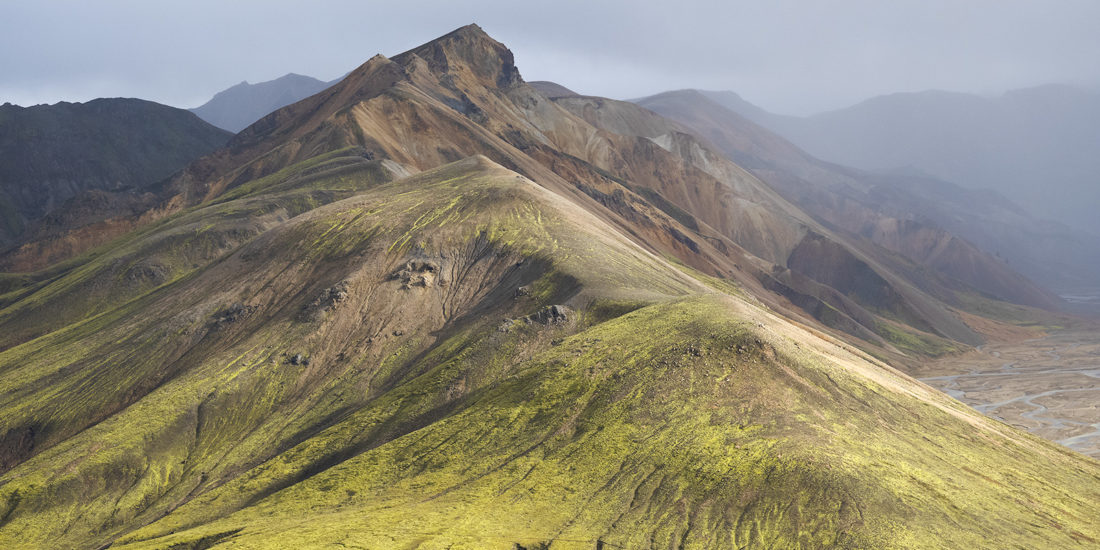 pents de montagne verte et ocre et rochers recouverts de mousse verte au Landmannalaugar en Islande