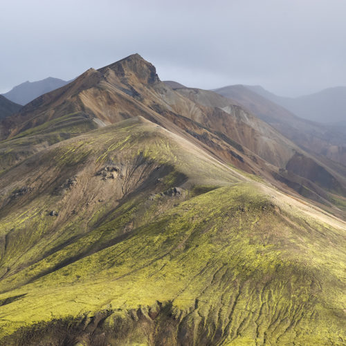 pents de montagne verte et ocre et rochers recouverts de mousse verte au Landmannalaugar en Islande