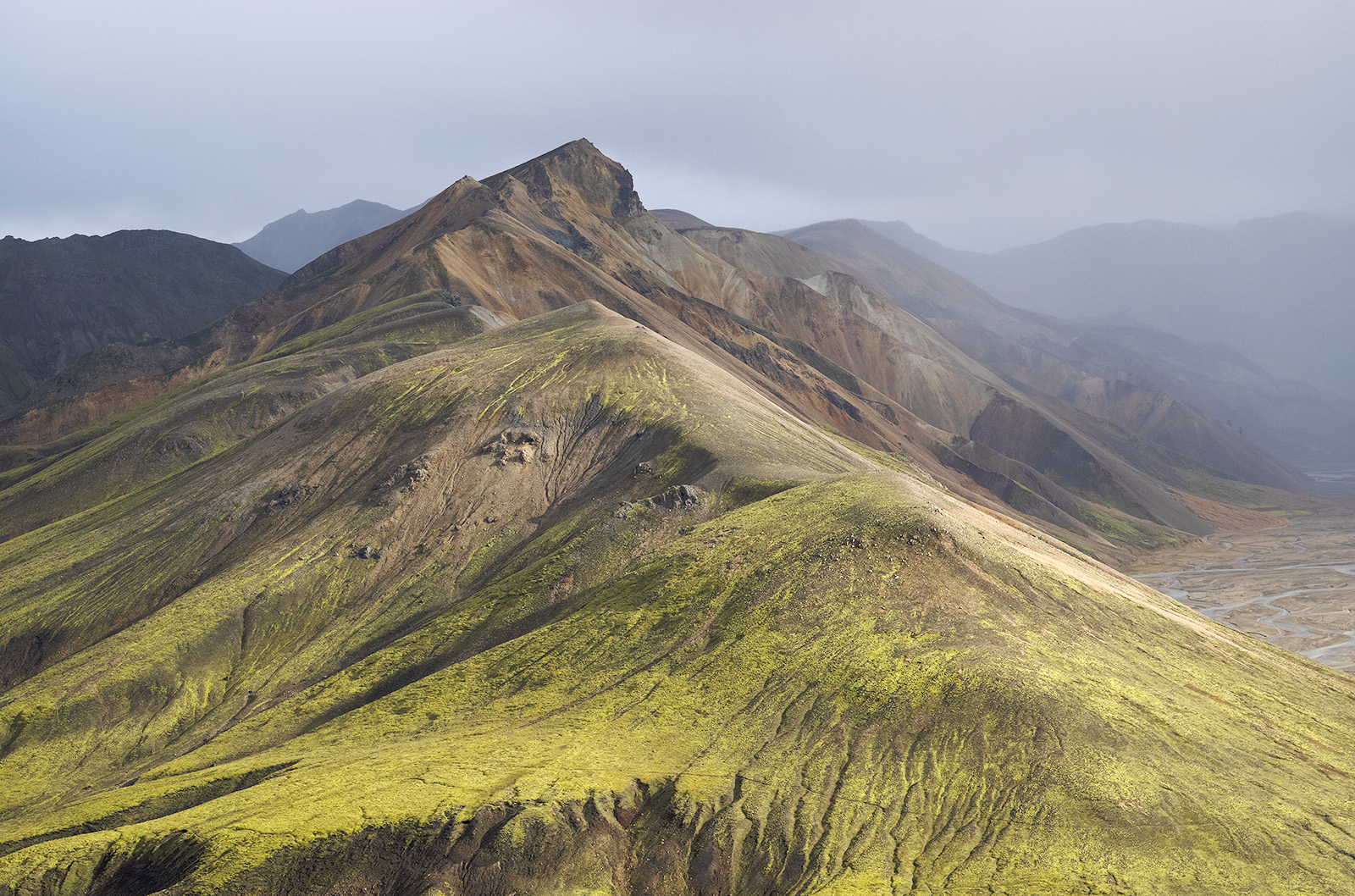 pents de montagne verte et ocre et rochers recouverts de mousse verte au Landmannalaugar en Islande
