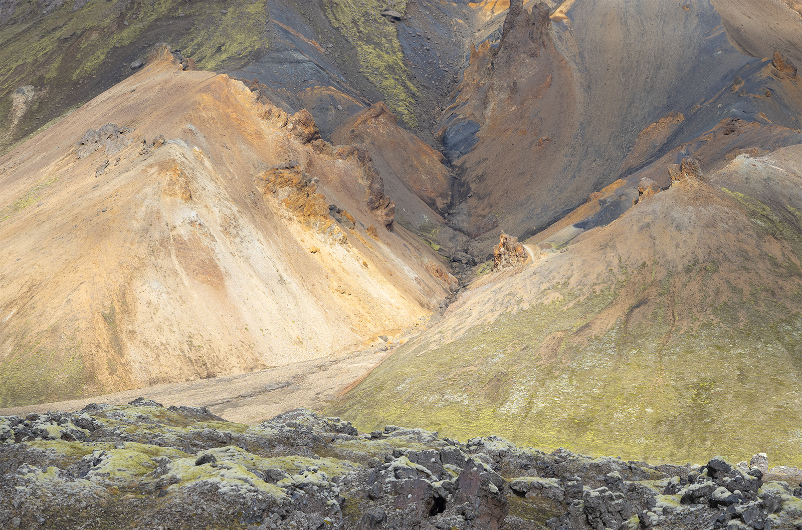pents de montagne verte et ocre et rochers recouverts de mousse verte au Landmannalaugar en Islande