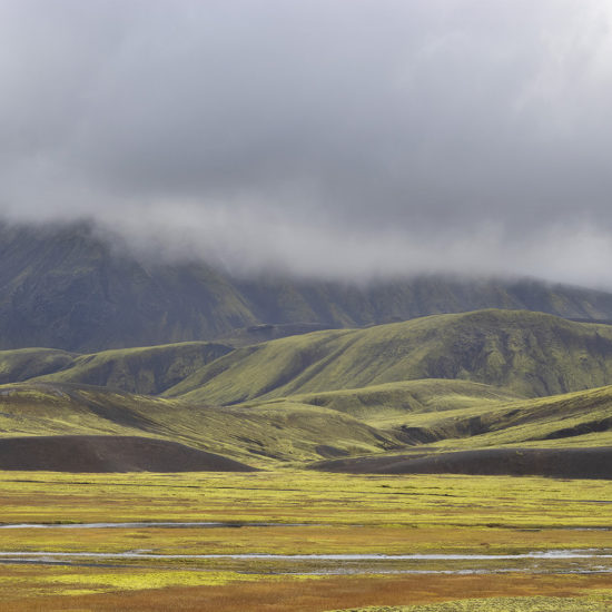 Plaine et montagne au fonds en couleurs jaune orange et vert dans le Landmannalaugar en Islande